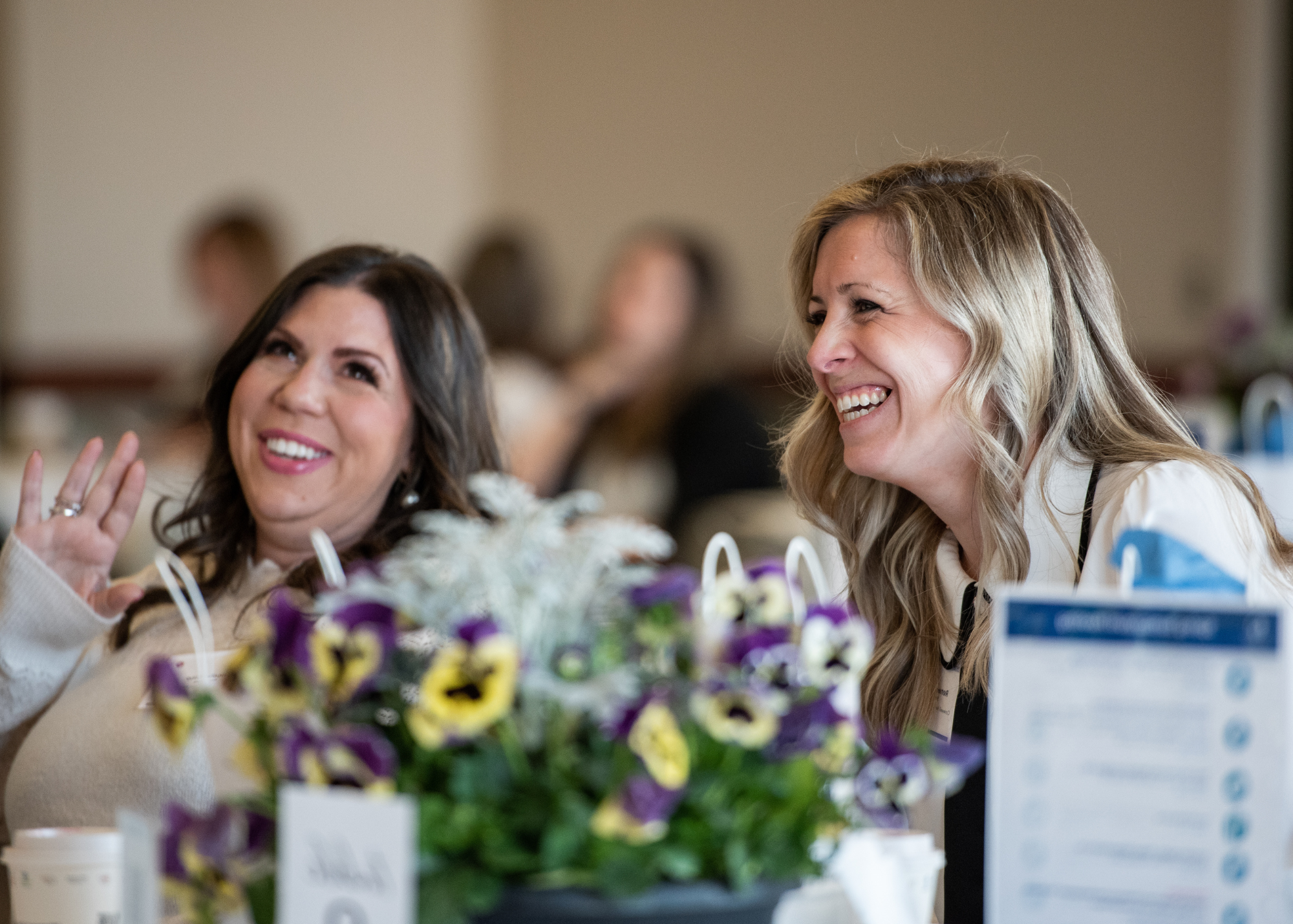 Two women laughing at semi-annual meeting